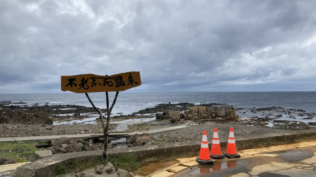 不老ふ死温泉の看板と日本海